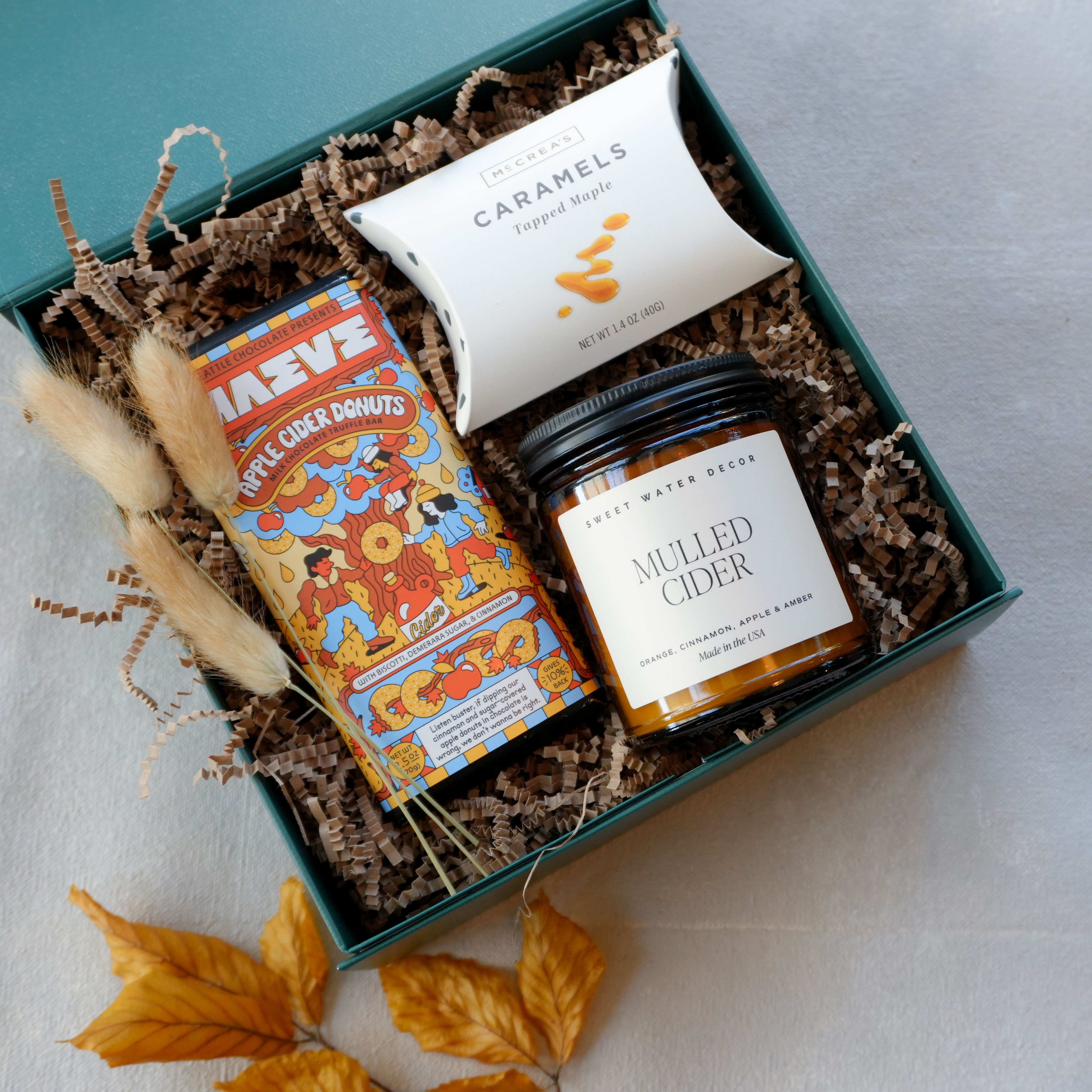 Curated autumn gift box with apple cider donut chocolate bar, caramels, and mulled cider candle. By Kraft & Co Floral and Gift
