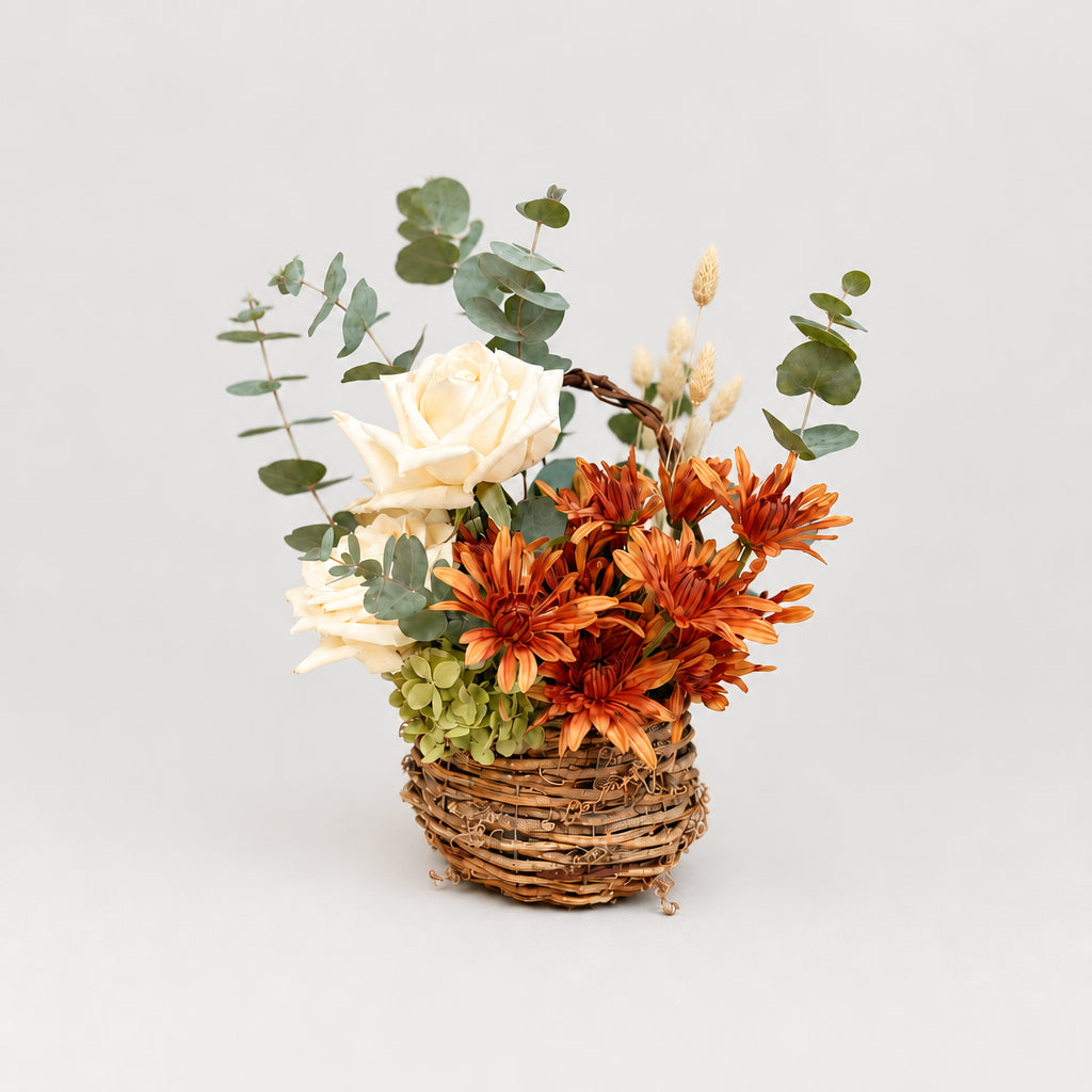 Gathered Basket, a rustic fall flower arrangement featuring warm autumn blooms, creamy roses, seasonal greenery and textural accents. Available for local flower delivery in the lehigh valley and surrounding areas